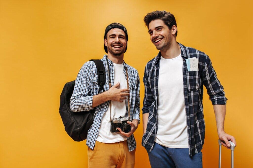 Good-humored young brunet men in checkered shirts and white t-shirts smile on orange background. Ch – nicotine pouches snus Casablanca Maroc